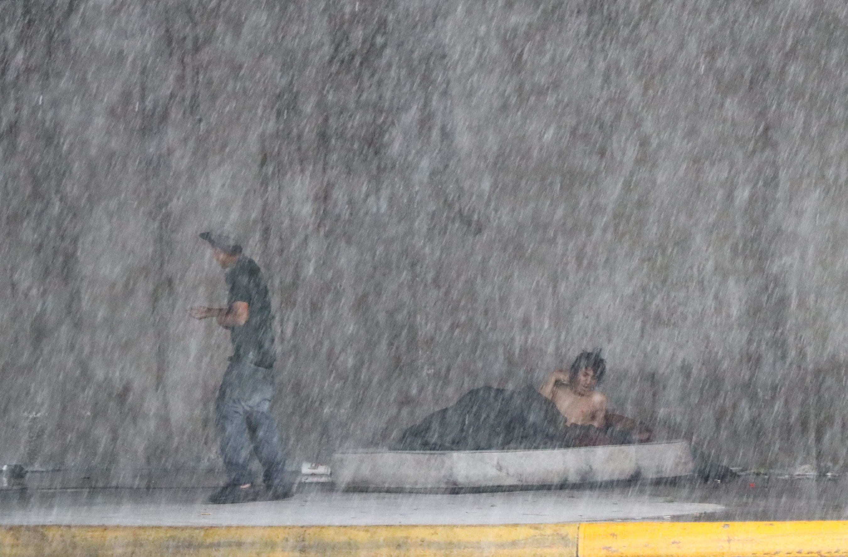 Una mujer habla por teléfono dentro de un autobús de transporte urbano que transita bajo la lluvia en la ciudad de Monterrey. (EFE/ Miguel Sierra)