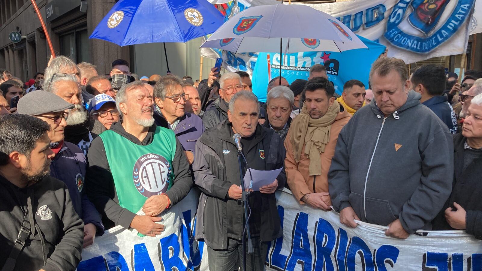 Juan Carlos Schmid (en el centro) habla durante la marcha ante el Ministerio de Desregulación