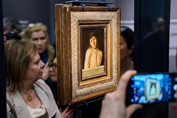 El cuadro "Ecce Homo" de Antonello da Messina, con marco dorado, exhibido en una galería de arte, mientras el público lo observa y fotografía