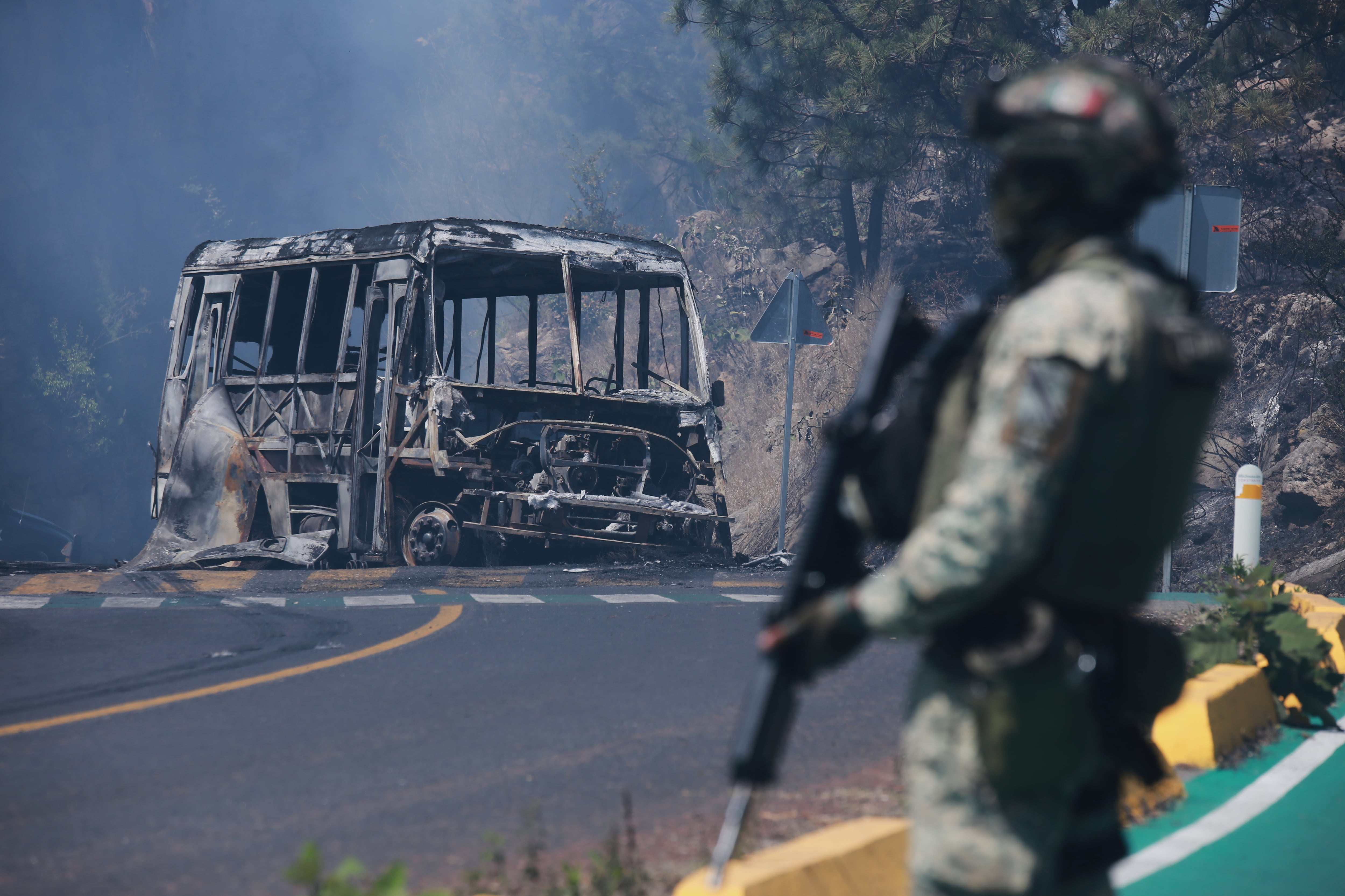 ARCHIVO – Un soldado monta guardia frente a un vehículo en llamas tras ser incendiado en Cointzio, Michoacán, México, el 22 de febrero de 2026, tras la muerte del líder del Cártel Jalisco Nueva Generación, Nemesio Oseguera, también conocido como