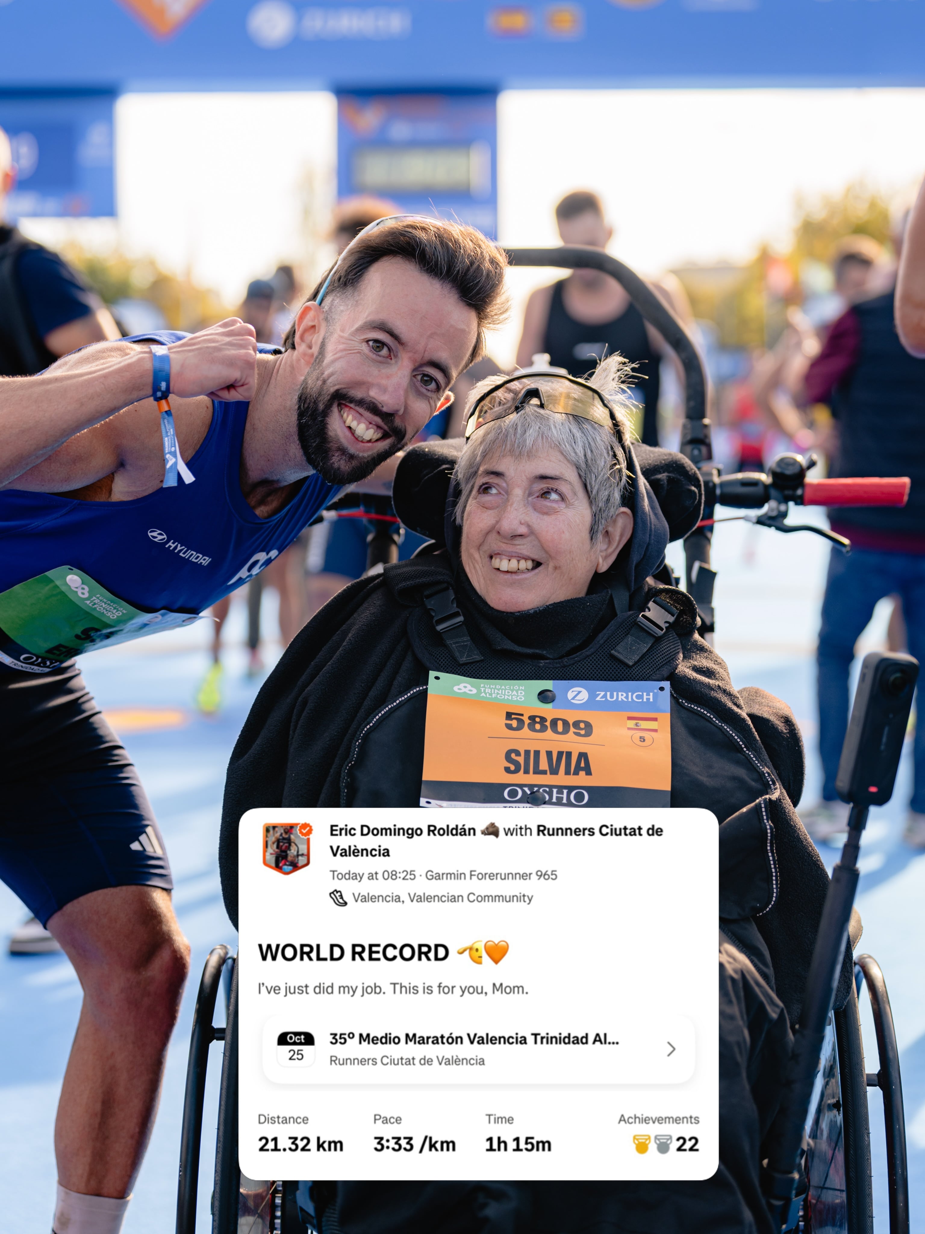Con 63 años, la mujer acompaña desde una silla de ruedas el esfuerzo del atleta durante los 21 kilómetros de la carrera valenciana, que concluye con una plusmarca mundial histórica (Eric Domingo Roldán)
