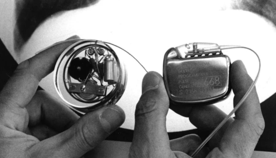 El primer marcapasos interno implantado a un ser humano tenía forma circular y disponía de dos transistores de silicio y una batería de níquel-cadmio recargable mediante un sistema externo. Lo fabricaron a mano y sus dimensiones estaban determinadas por el molde donde fue fijado a la resina que lo recubría: una cajita de betún para zapatos de la marca British Kiwi (Siemens Healthineers Historical Institute)