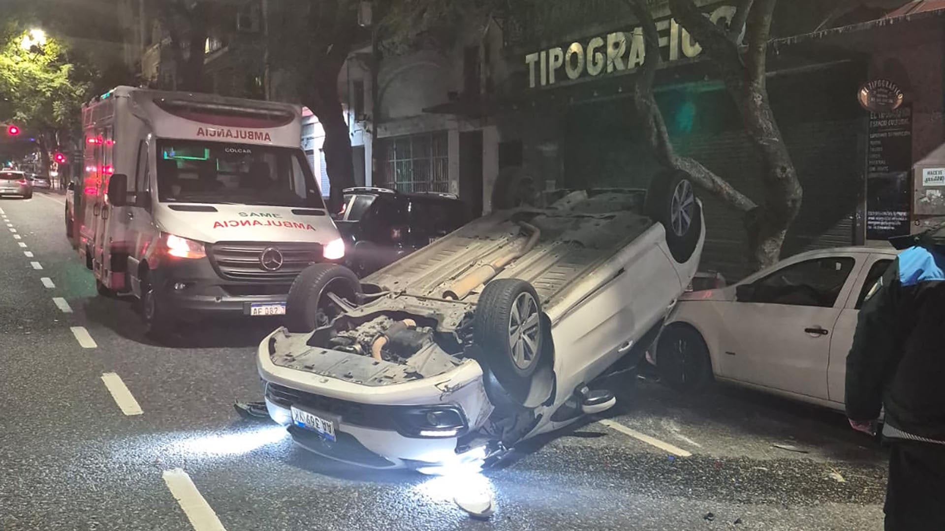 Un automóvil permanece volcado sobre el asfalto junto a una ambulancia del SAME tras un siniestro vial en el barrio de San Cristóbal.