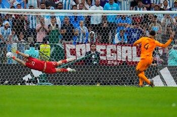El arquero argentino Emiliano Martínez ataja el remate del neerlandés Virgil van Dijk en la tanda de penales del duelo de cuartos de final del Mundial, el viernes 9 de diciembre de 2022, en Lusail, Qatar. (AP Foto/Natacha Pisarenko)