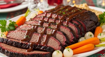 Primer plano de brisket de ternera en rodajas con salsa marrón, adornado con zanahorias baby, cebollas perla y ramitas de perejil en una fuente blanca.