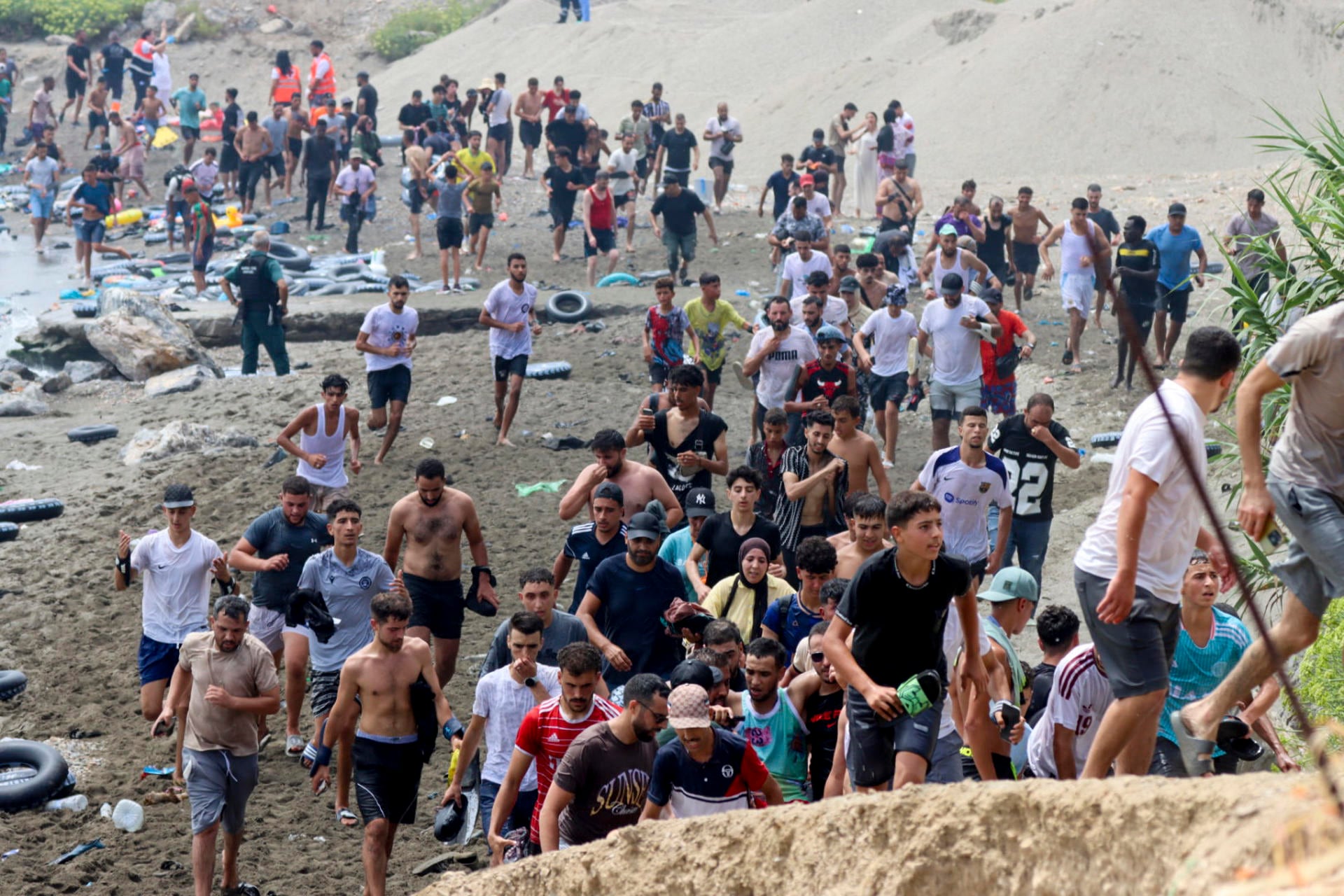 La imagen recoge a parte de los miles de personas que han intentado acceder a Ceuta durante las últimas horas bordeando el espigón del Tarajal o entrando a nado desde Marruecos. La llegada continuada de nuevos grupos ha obligado a mantener un amplio dispositivo de rescate, identificación y atención humanitaria. (EFE)