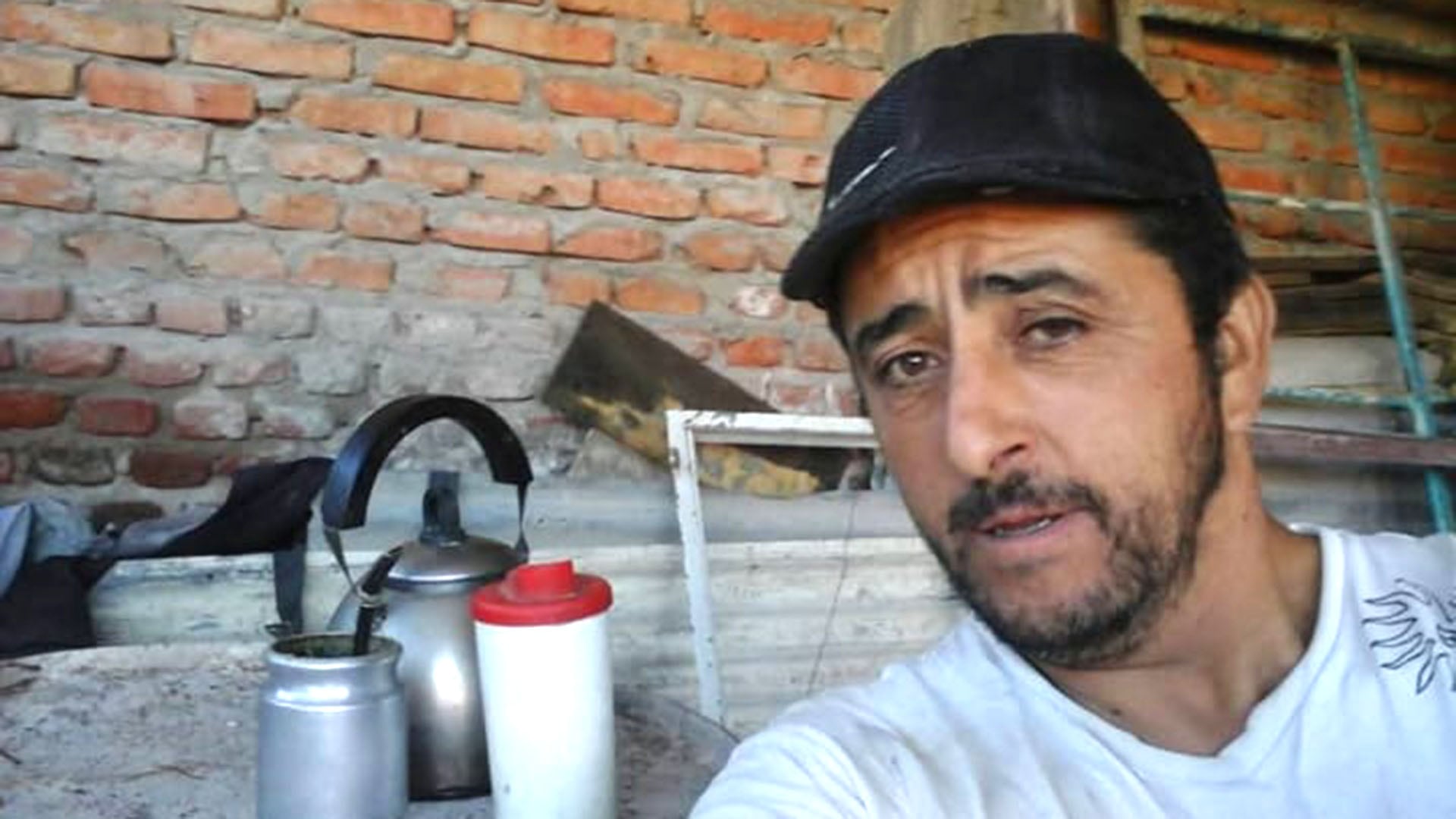 Misael Arias Chavez, acusado de abuso de menores en Trelew, se muestra en esta imagen con un fondo de ladrillos y elementos para preparar mate. (Facebook)