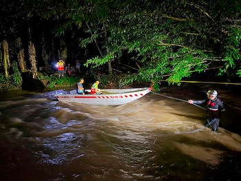 Rescatistas atraviesan un río crecido durante la noche para evacuar a personas afectadas por las inundaciones en la Zona Norte de Costa Rica (Cortesía: Cruz Roja).
