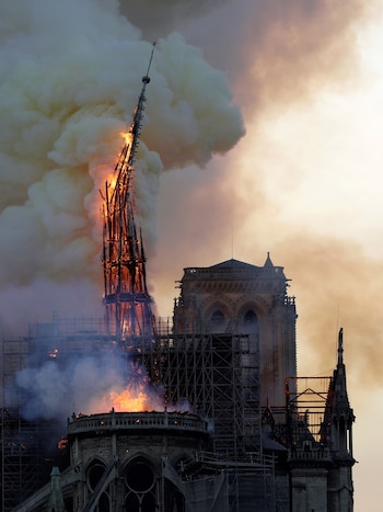 La aguja de la catedral de Notre Dame en el momento que se desmoronó producto del incendio de abril de 2019 (AFP)