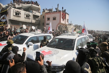 Una multitud rodea los vehículos