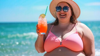 Mujer joven con cuerpo plus size caminando alegremente por la orilla del mar, disfrutando de la sensación de la arena y el agua en sus pies. La imagen refleja el disfrute y la positividad de las vacaciones de verano, independientemente del tipo de cuerpo, y promueve una imagen saludable y positiva del cuerpo. (Imagen ilustrativa Infobae)