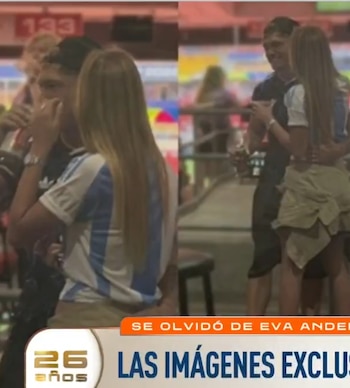 Ian Lucas, de espaldas con gorra negra y camiseta Adidas, abraza a Renata Mónaco, quien lleva una camiseta de Argentina y cabello rubio largo suelto, en un lugar iluminado