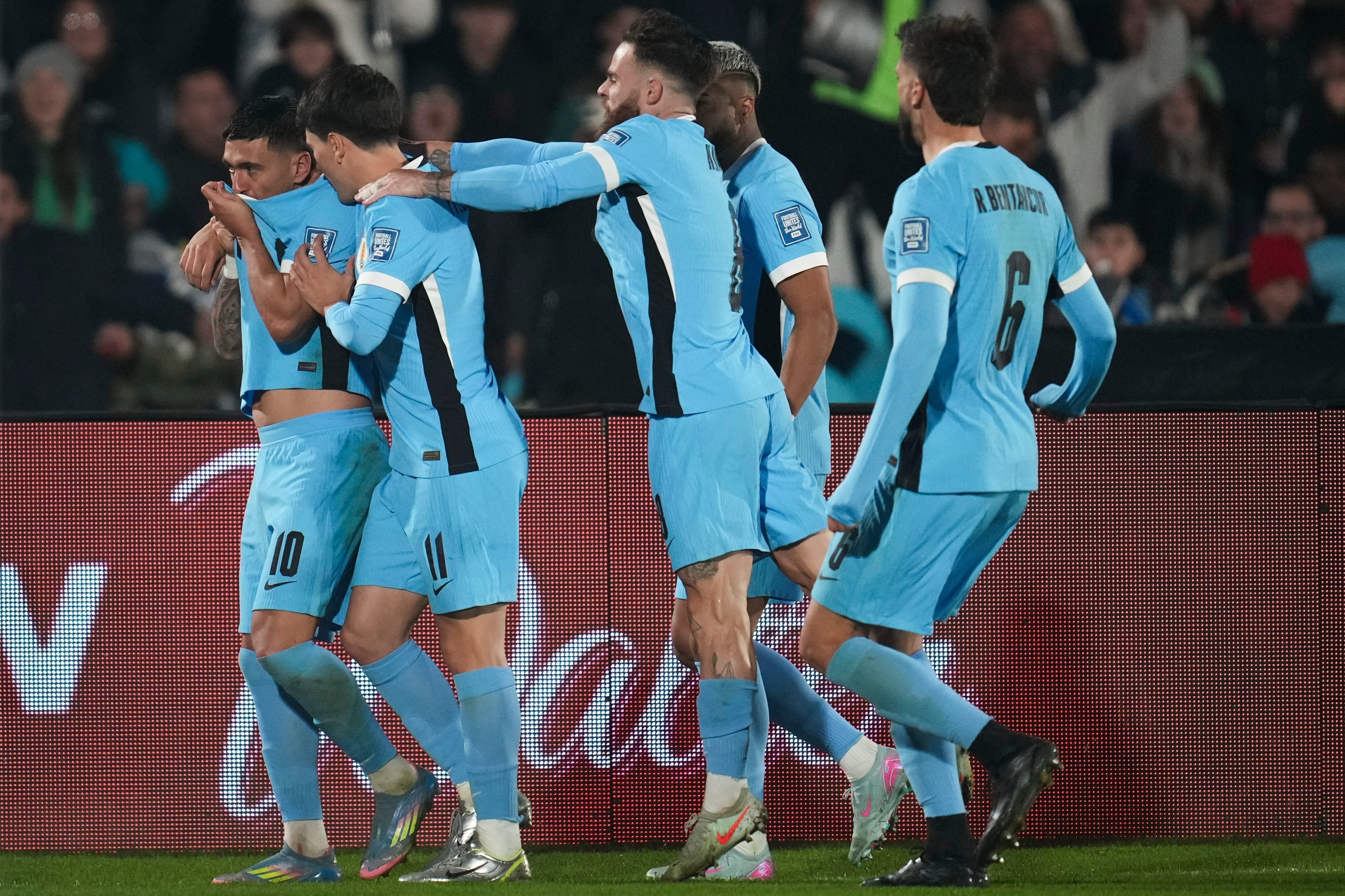 Giorgian de Arrascaeta (izquierda) festeja con sus compañeros de la selección de Uruguay luego de anotar ante Venezuela en el encuentro de la eliminatoria mundialista disputado el martes 10 de junio de 2025 (AP Foto/Matilde Campodonico)