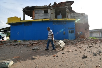 Un hombre camina frente a una vivienda dañada en Morón, cerca del epicentro de dos sismos que sacudieron Venezuela el día anterior, el jueves 25 de junio de 2026. (AP Foto/Jacinto Oliveros)