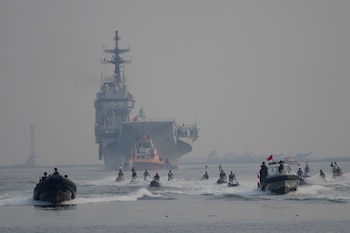 Personal de la Armada de Indonesia escolta al Giuseppe Garibaldi, un antiguo portaaviones de la Armada italiana (en el centro, al fondo), a su llegada al puerto de Tanjung Priok en Yakarta, Indonesia, el viernes 18 de septiembre de 2026 (AP/Tatan Syuflana)