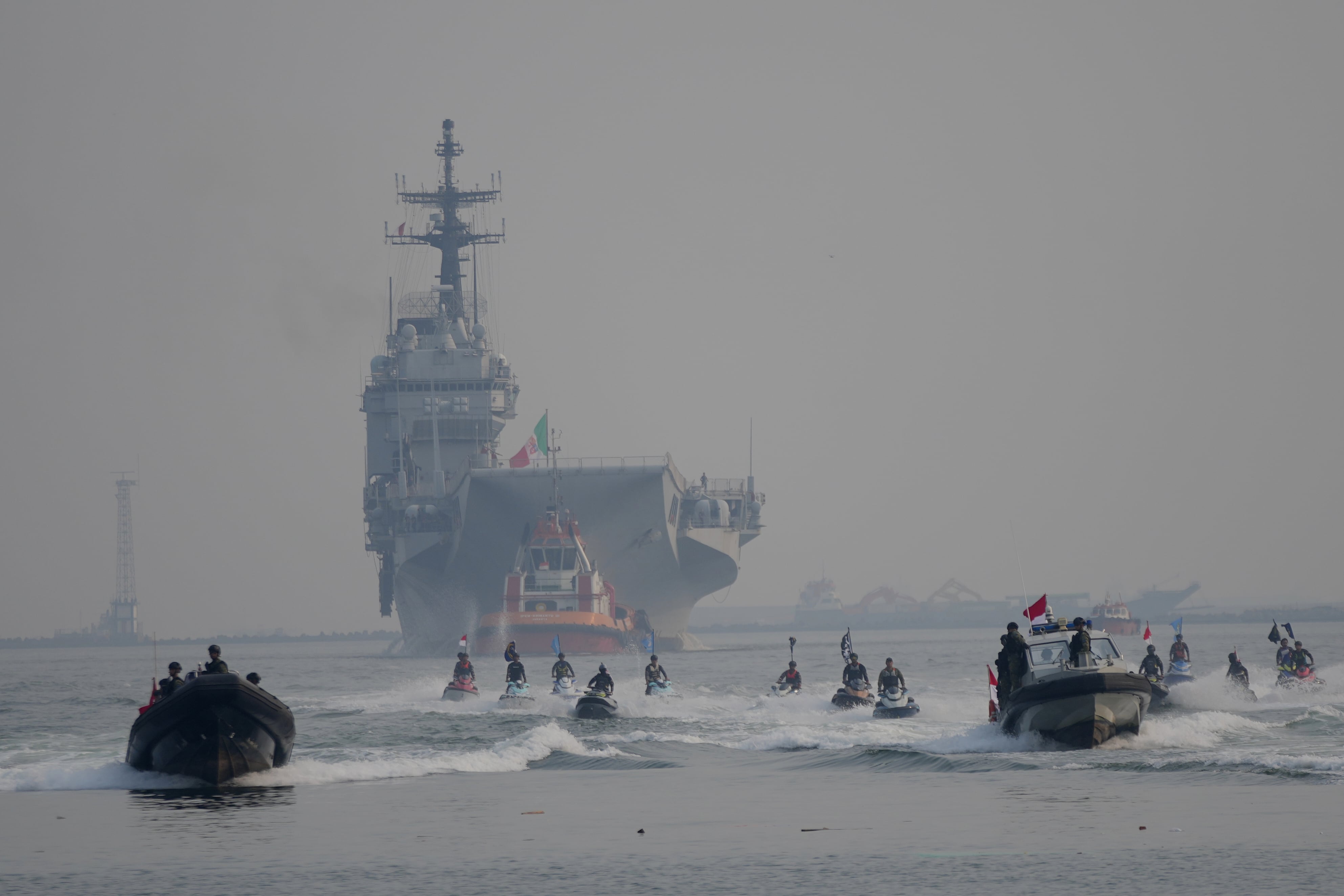 Personal de la Armada de Indonesia escolta al Giuseppe Garibaldi, un antiguo portaaviones de la Armada italiana (en el centro, al fondo), a su llegada al puerto de Tanjung Priok en Yakarta, Indonesia, el viernes 18 de septiembre de 2026 (AP/Tatan Syuflana)