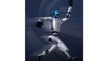 Un robot humanoide plateado de Unitree Robotics en pose dinámica, con el brazo izquierdo levantado y la cabeza con una luz azul brillante