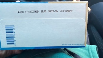 Primer plano de una caja blanca con un código de barras impreso y datos de lote, elaboración y vencimiento en tinta negra sobre el cartón