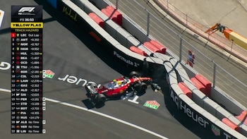 Un monoplaza de carreras rojo y blanco tras impactar contra las barreras de protección en la curva de un circuito