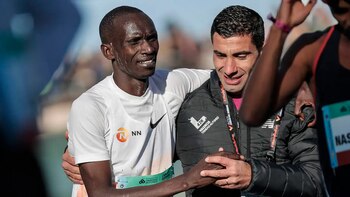 An exhausted Cheptegei assisted by