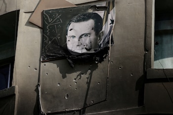 Un retrato de Bashar al Assad, dañado por disparos, cuelga en la pared de un edificio incendiado del Departamento de Seguridad Criminal tras el derrocamiento del dictador sirio, en Damasco, Siria, el 20 de diciembre de 2024 (REUTERS/Archivo)