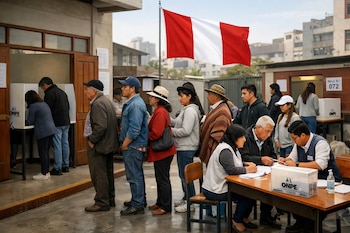 Una multitud de personas en Perú hace fila para votar en un centro electoral bajo una bandera peruana. Se ven cabinas de votación y mesas de registro con personal electoral.