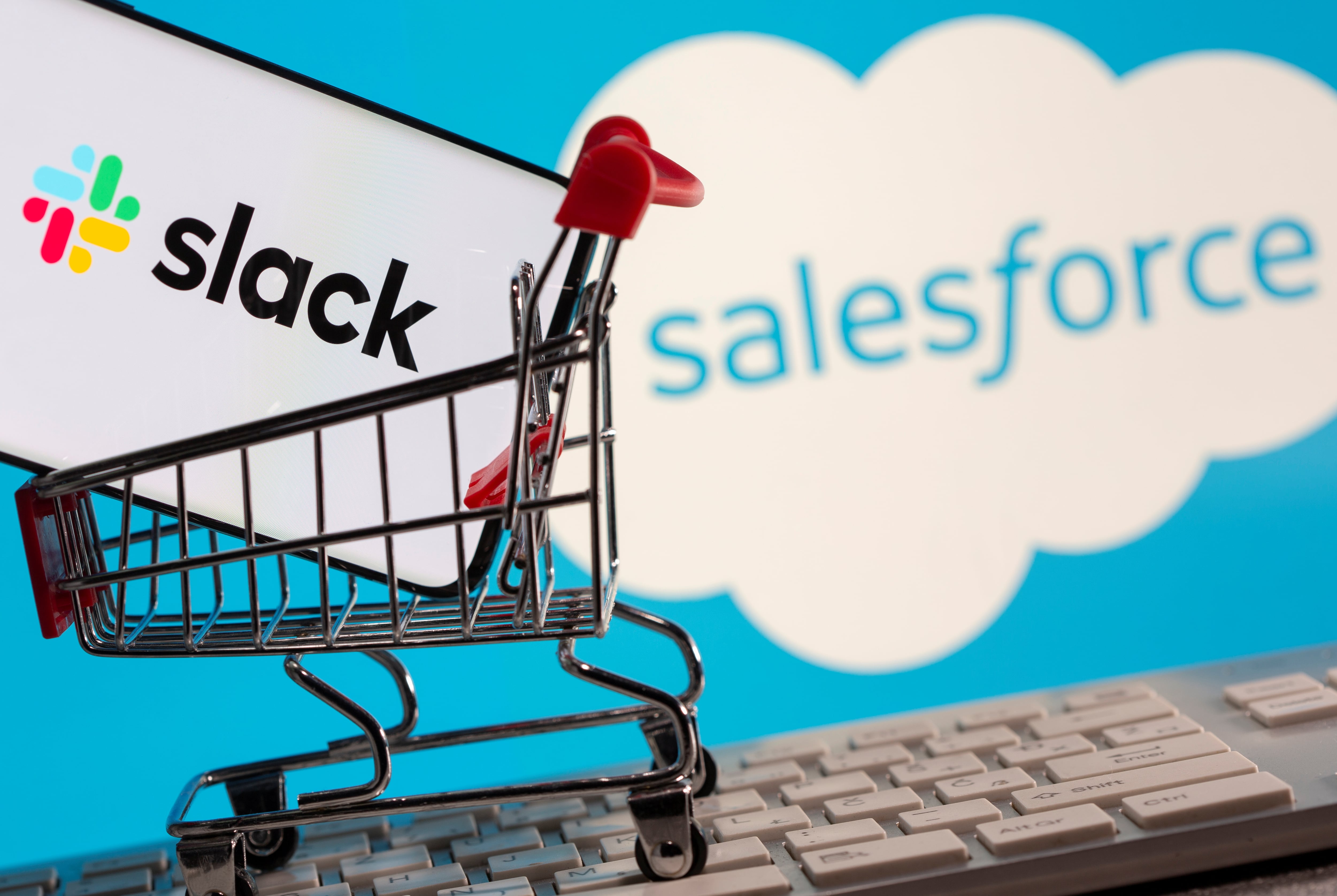 Smartphone with Slack logo stands in a shopping cart on a keyboard in front of displayed Salesforce logo in this picture illustration taken December 1, 2020. Picture is taken December 1, 2020. REUTERS/Dado Ruvic/Illustration