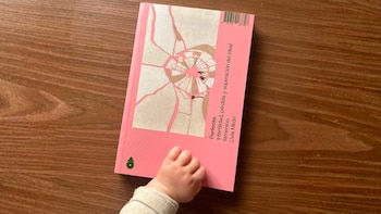 Una mano de bebé se acerca a la portada del libro 'Perfecta. Infertilidad, pérdida y superación del ideal femenino', de Livia Mirón.