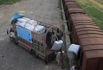 Trabajadores cargan sacos de productos