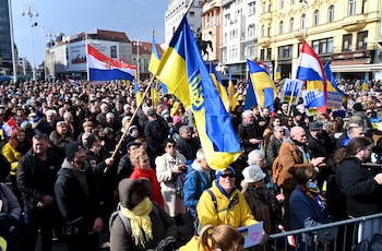 Manifestantes sostienen pancartas con mensajes