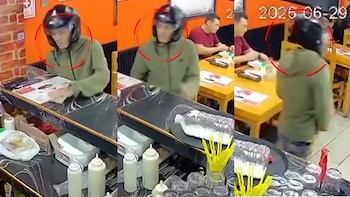 Secuencia de cámara de seguridad muestra a un hombre con casco y chaqueta verde frente a un mostrador de pollería. Clientes sentados al fondo, fecha 2025-06-29