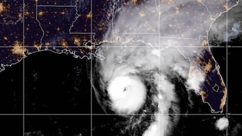 Vista satelital de una tormenta ciclónica en el mar, con líneas de fronteras estatales en blanco y luces urbanas nocturnas