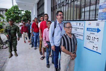 Varias personas hacen fila para