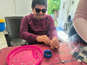 Persona con sordoceguera participa en un taller de manualidades promovido por FUSSDIM, como parte de las actividades para potenciar la autonomía y la inclusión social (Cortesía).