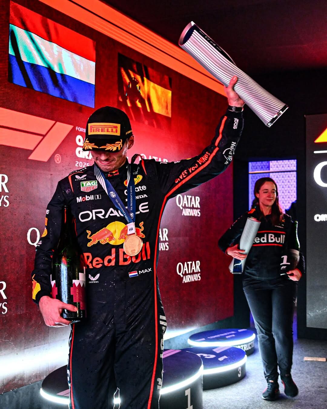 Max Verstappen con el trofeo tras ganar en Qatar y detrás aparece Hannah Schmitz (@hannahschmitzf1)
