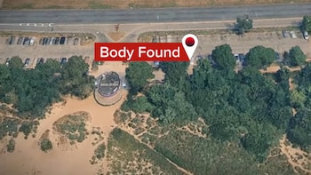 Vista aérea de una carretera, vegetación, estacionamiento y un marcador rojo gráfico con el texto en inglés Body Found