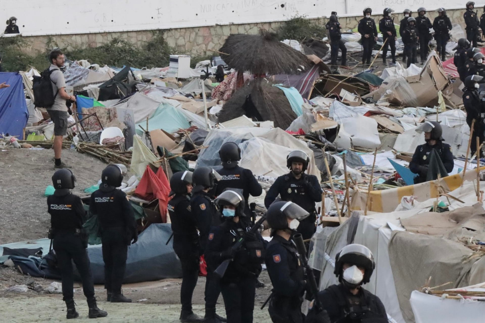 La Policía desaloja el asentamiento de migrantes junto a la desalinizadora de Ceuta: serán llevados cerca de la playa del Trampolín