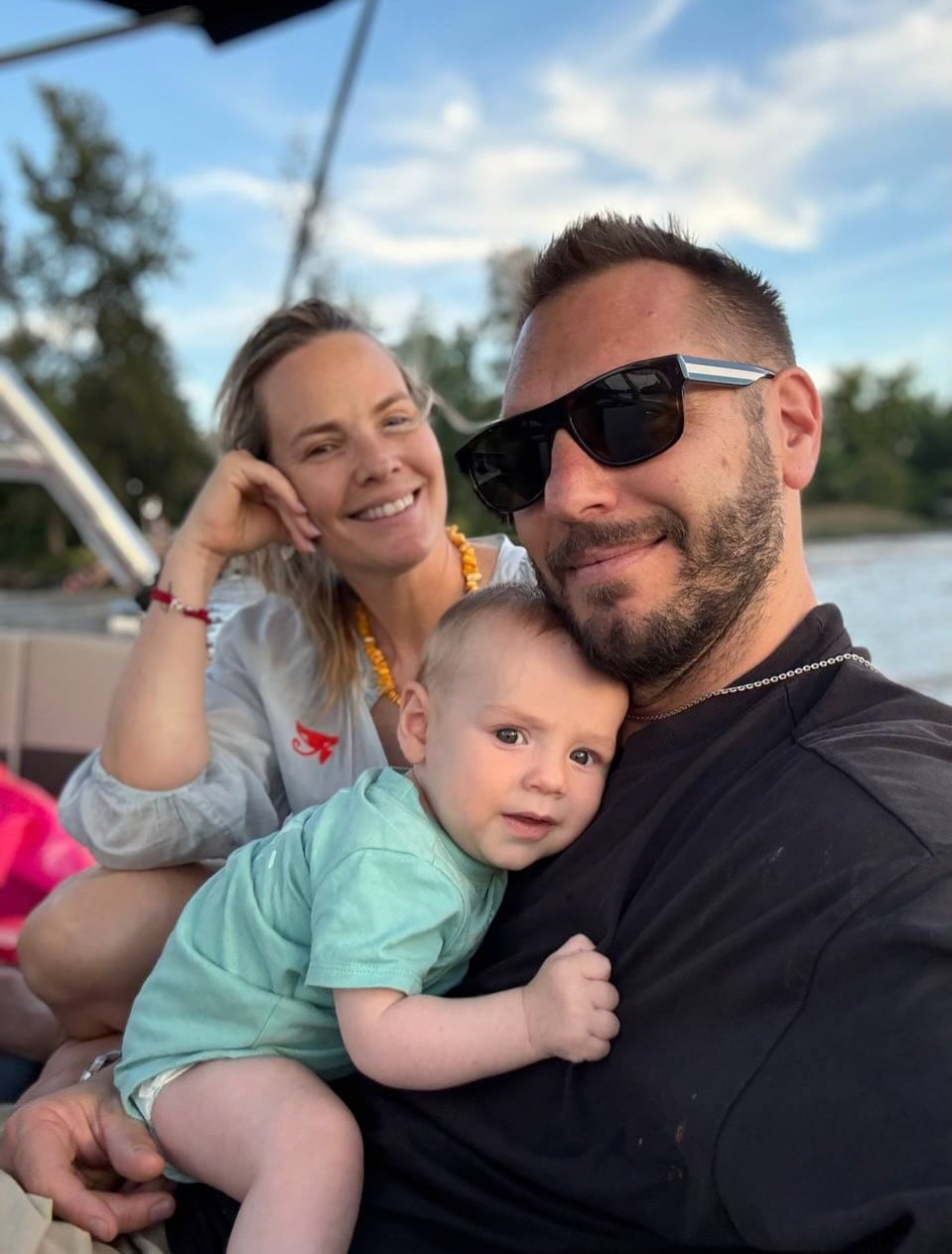 Muni, sonriente, junto a su pareja y su hijo Vicente en un barco, celebrando el primer año de vida del pequeño con alegría