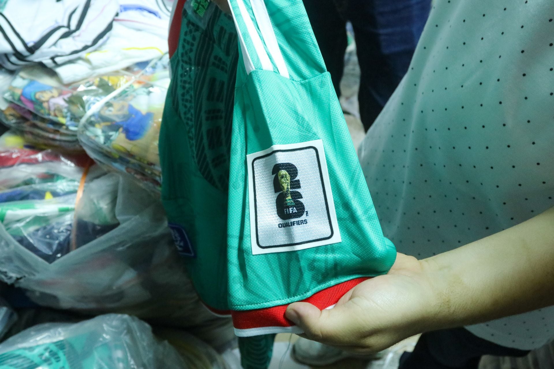 Elementos de seguridad inspeccionan una playera deportiva presuntamente apócrifa del Mundial 2026 durante un operativo contra la piratería en Tepito, Ciudad de México. (Cuartoscuro)