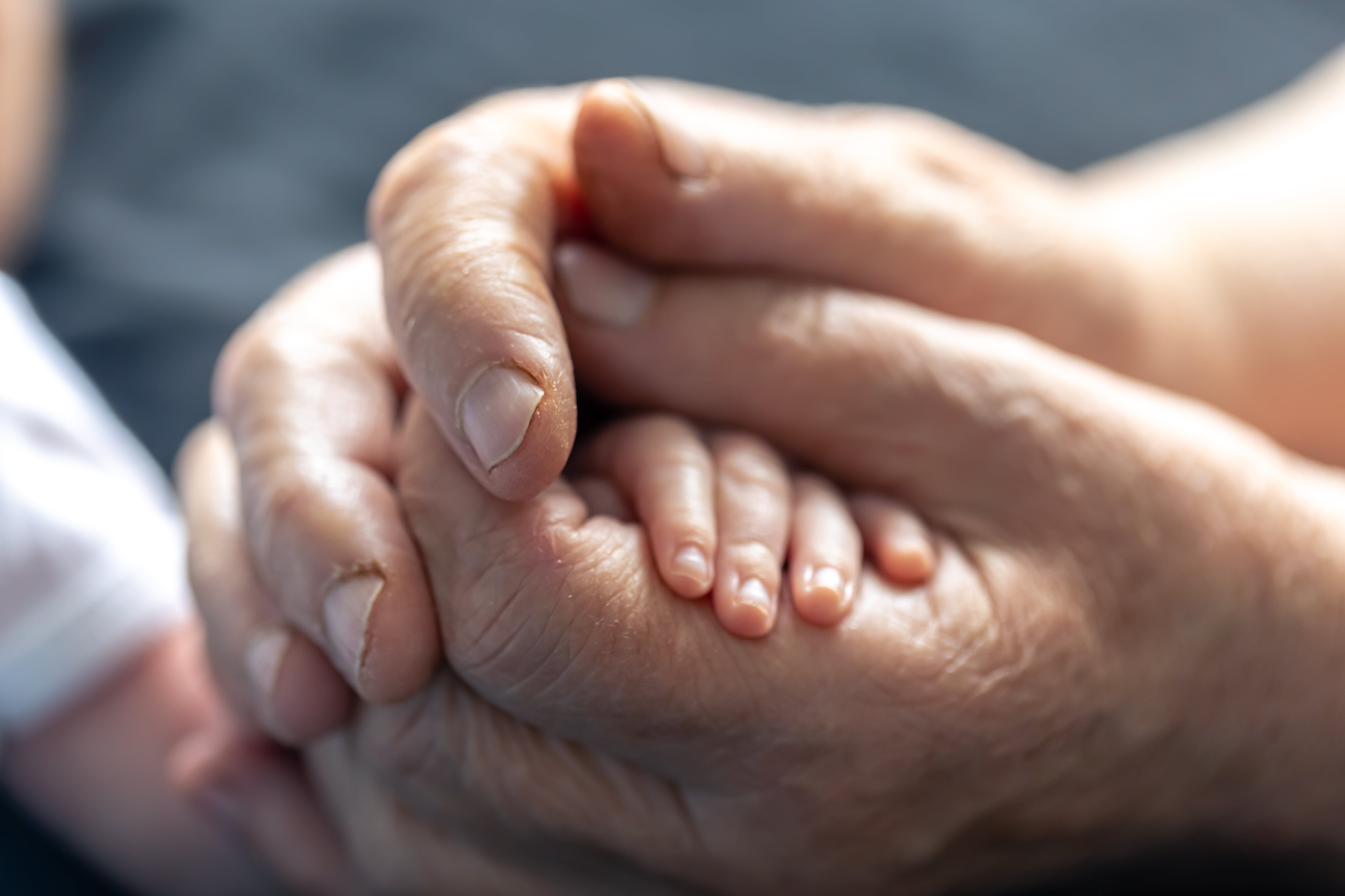 Una abuela sosteniendo la mano de un bebé (Freepik)