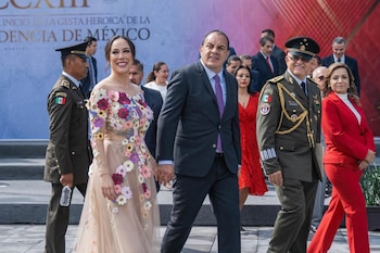 Cuauhtémoc Blanco camina tomado de la mano de Natalia Rezende Moreira frente a un fondo oficial, junto a militares y funcionarios