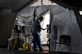 Un trabajador sanitario atiende a varios pacientes en el interior de una tienda con suministro de oxígeno en el esterior el área de urgencias del Hospital Comunitario de Huntington Park, estado de California, Estados Unidos, el 29 de diciembre de 2020. REUTERS/Bing Guan