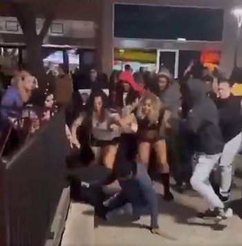 Fotografía borrosa de un grupo de personas en un espacio interior, algunas en movimiento y una en el suelo en el primer plano