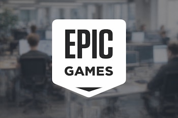 Logotipo de Epic Games en blanco y negro en el centro de la imagen. Al fondo, una oficina con empleados trabajando en sus escritorios, difuminada.