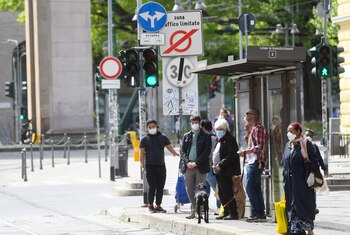 Personas con máscaras protectoras esperan en una parada de autobús en una calle cada vez más concurrida, en medio del brote del
coronavirus, en Milán, Italia (Reuters)