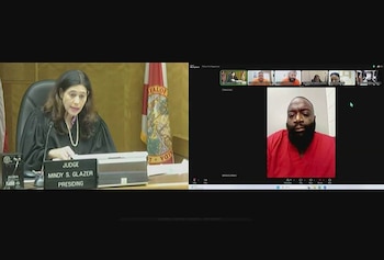 Pantalla dividida con una jueza en un estrado judicial a la izquierda y la videollamada de un hombre con barba y prenda roja a la derecha