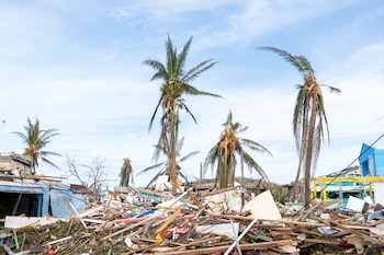 Damaged houses and debris are