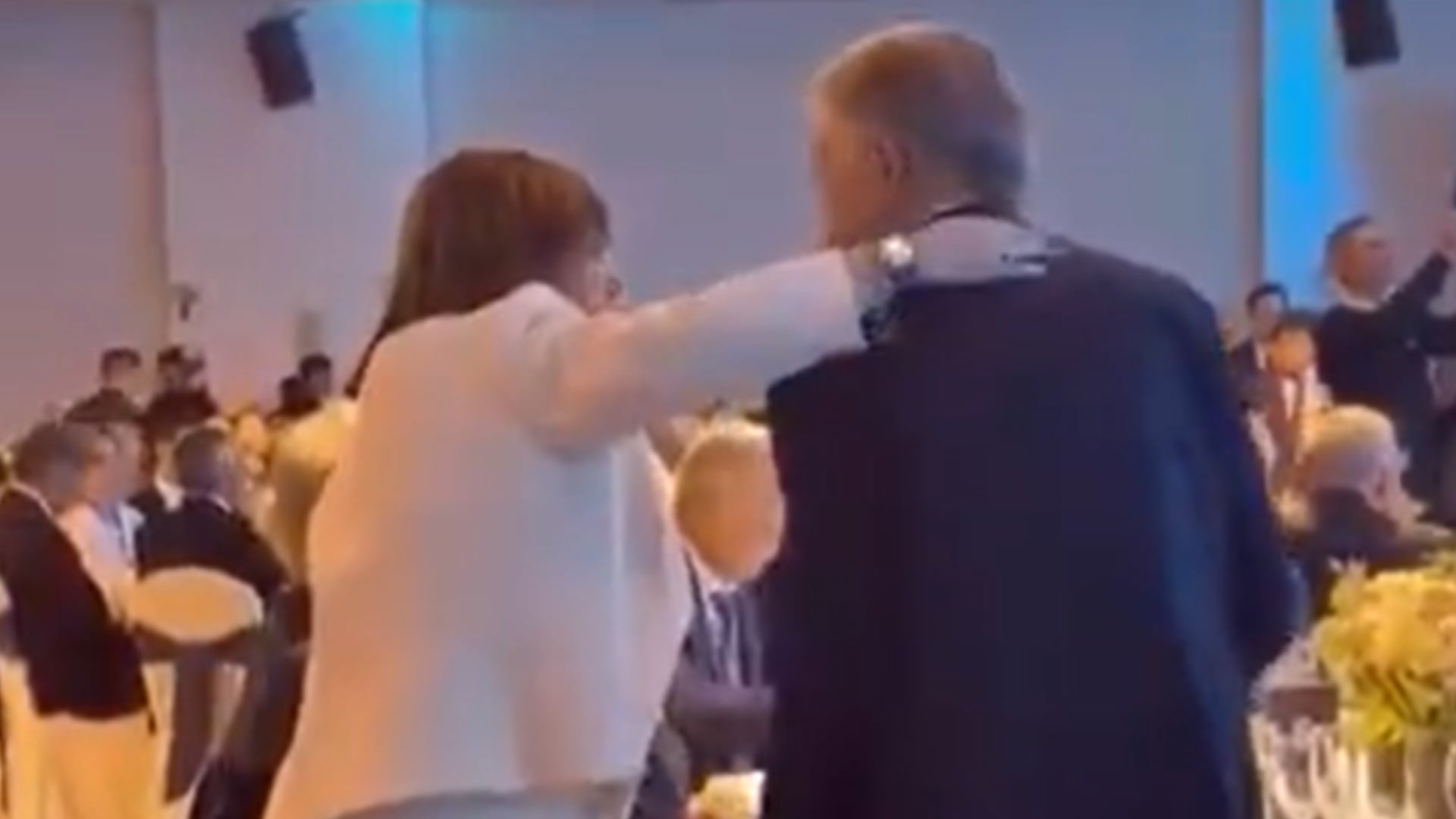 Patricia Bullrich saluda a Mauricio Macri en un evento de la Fundación Libertad con otros asistentes en el fondo.