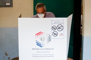 Personas asisten a votar durante