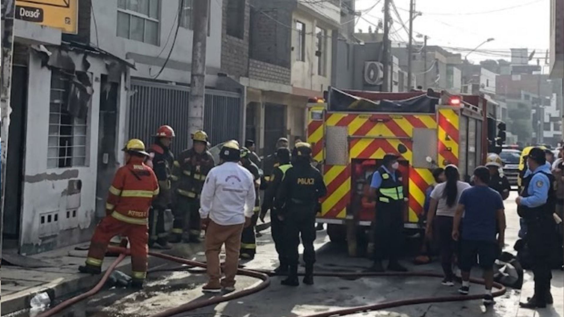 Integrantes del cuerpo de bomberos y agentes policiales atienden una emergencia en un inmueble en una zona urbana. (Panamericana)